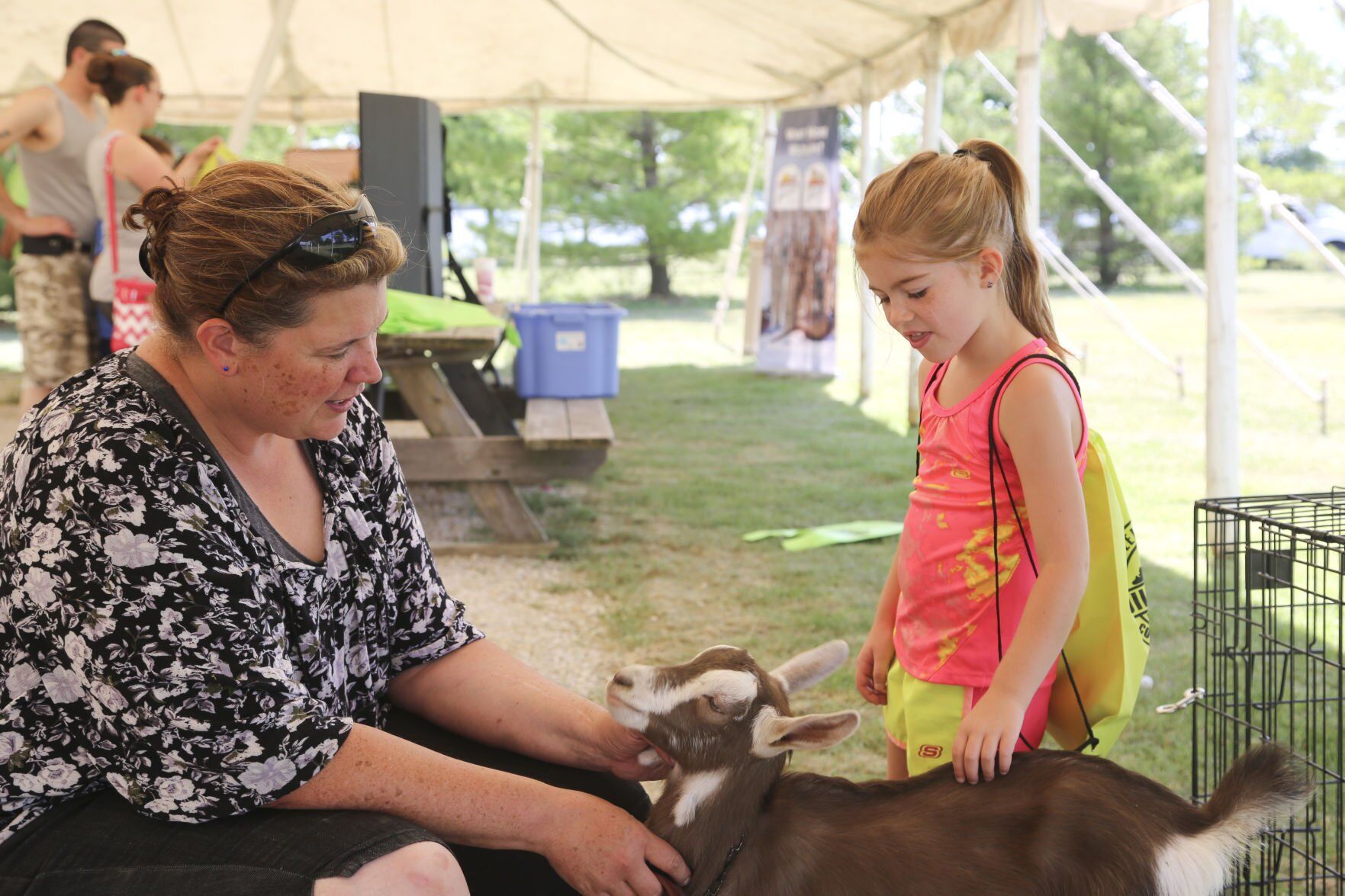 Jenny Henkel holds her goat Beach for a little girl